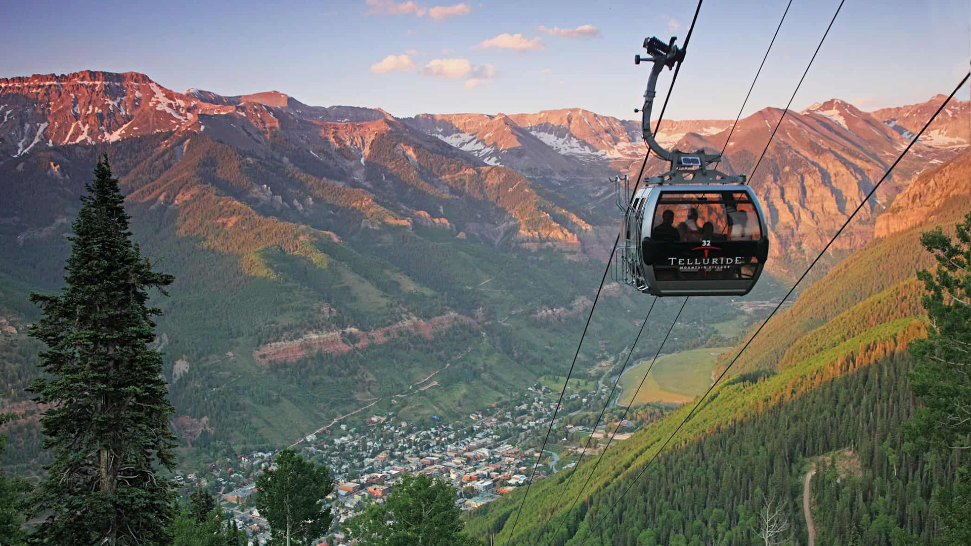 A Telluride gondola cabin above town with the mountains at sunset