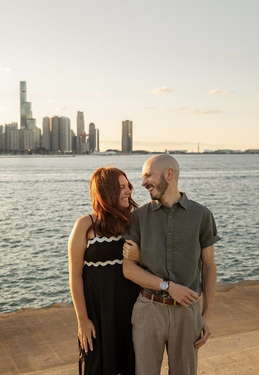 Kyle and Karli laughing and looking at each other by the lake at sunset