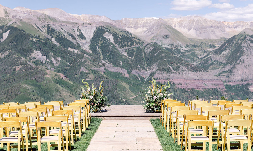 Ceremony chairs and a floral arch at San Sophia Overlook beneath the mountains